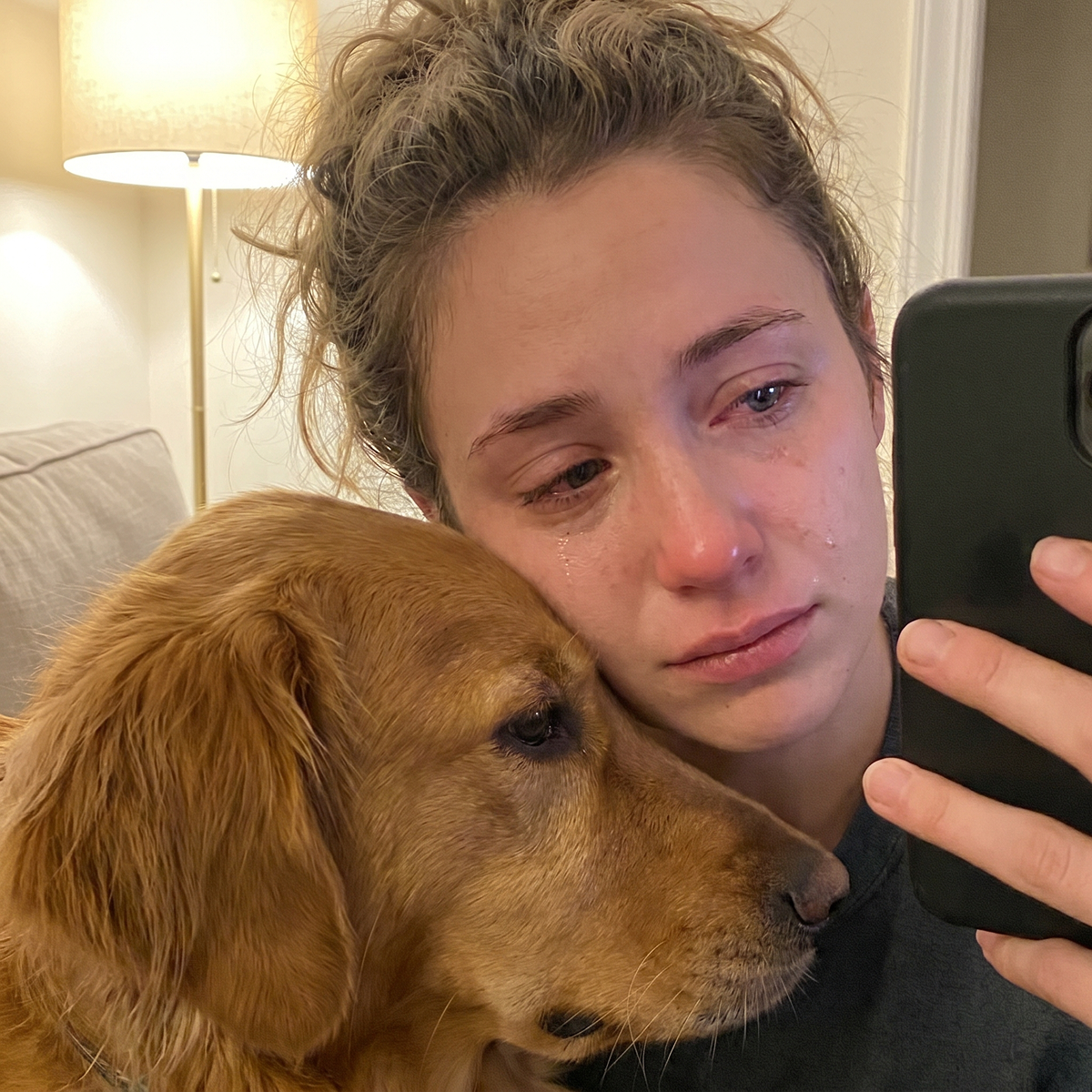 A woman crying with her dog